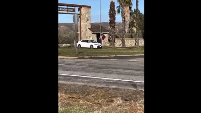 Crystal Aguilar subiendo la bandera de México en un parque en California.