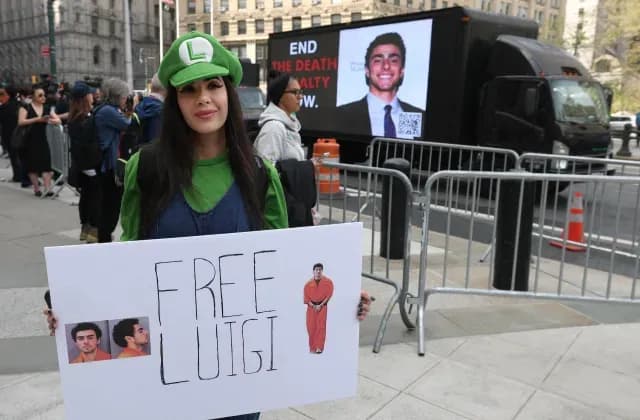 Manifestante con una pancarta en apoyo a Luigi Mangione