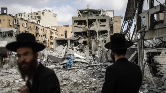 Habitantes de Israel pasan frente a edificio atacado en Irán