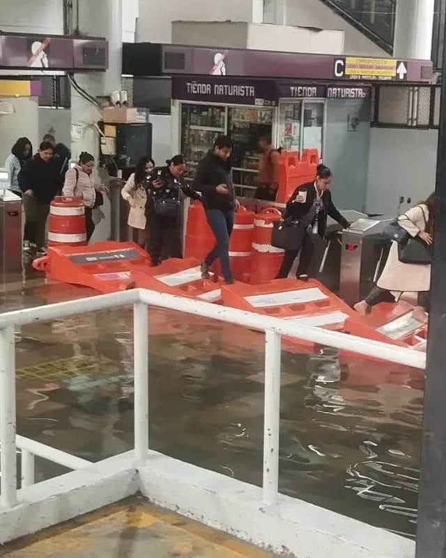 Usuarios pasan sobre inundación en Metro Pantitlán. Foto: N+