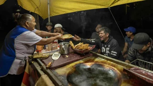 Integrantes de la familia Espinosa ríen y disfrutan de la cena en un puesto de antojitos mexicanos.