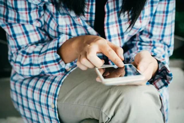 Mujer envía un mensaje de texto desde su celular