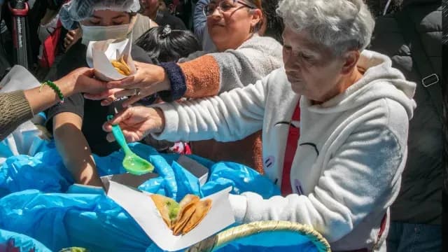 Una señora se prepara sus tacos de canasta con salsa verde. Foto: Cuartoscuro