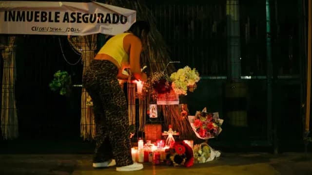 Una mujer coloca una ofrenda a las afueras del bar 'Los Cantaritos' en Querétaro. Foto: Cuartoscuro