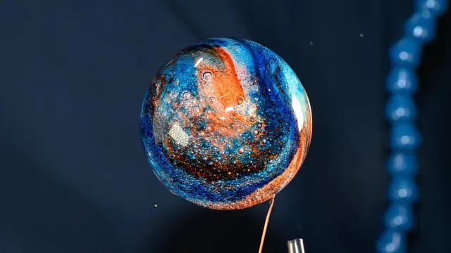 Esfera de agua llena de colorante alimentario en microgravedad