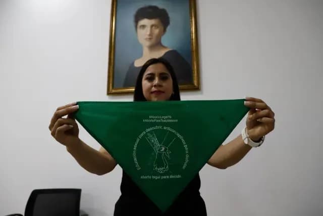Olimpia Coral sostiene un pañuelo verde del movimiento feminista en 2021