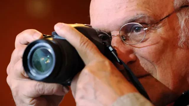 Carlos Saura con cámara fotográfica