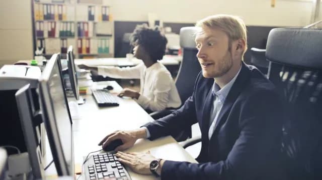 Hombre impresionado ante una computadora