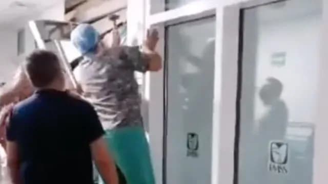 Trabajadores tratan de rescatar a la pequeña niña que resultó prensada en el elevador del IMSS. Foto: N+