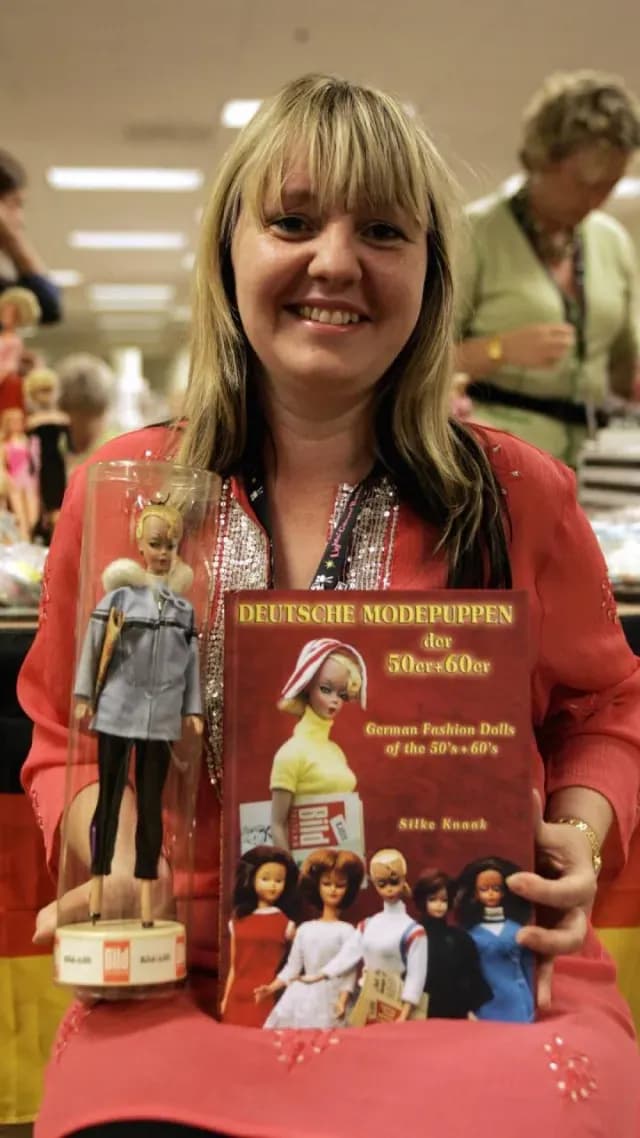 La coleccionista de muñecas Silke Knaak, de Hamburgo, Alemania, posa con su libro y una muñeca Lili original