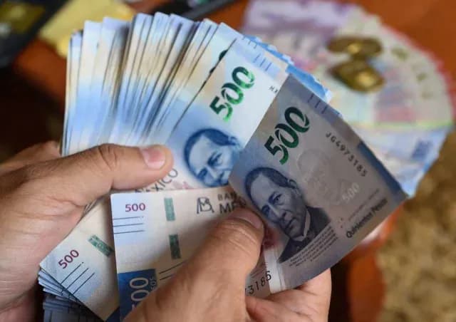Persona sostiene varios billetes de 500 pesos mexicanos