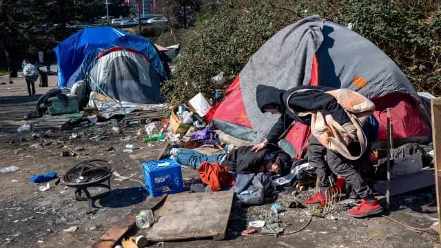 Personas en situación de calle en un campamento improvisado.