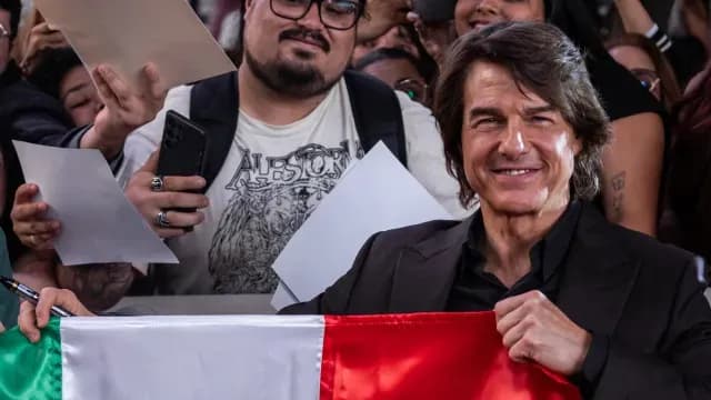 El actor Tom Cruise sostuvo una bandera de México durante la alfombra roja de su nueva película.
