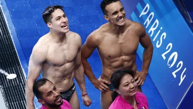 Osmar Olvera y Juan Celaya, junto a sus entrenadores, miran su calificaciones. Foto: Reuters