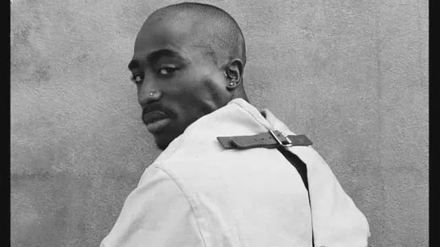 El rapero Tupac mientras posa con una camisa de fuerza