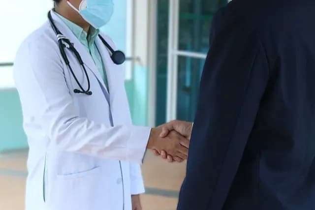 Un doctor saludando con la mano a un paciente