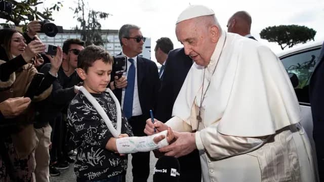El papa firma yeso del brazo de un niño. Foto: EFE