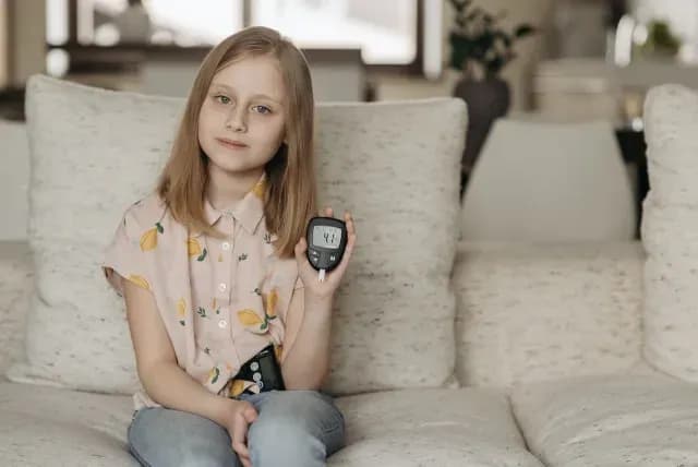 Niña con diabetes mide su nivel de azúcar en la sangre con un glucómetro