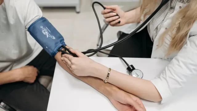 Médica revisa la presión sanguínea de paciente