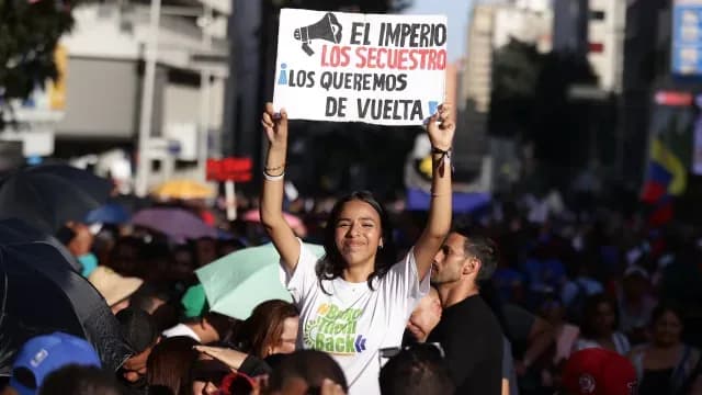 Mujer sostiene una pancarta sobre Nicolás Maduro y Cilia Flores