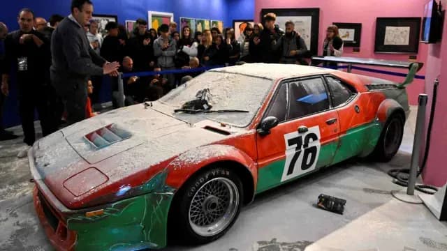 Visitantes miran el auto pintado por Andy Warhol, tras el ataque con harina por parte de activistas ambientales en Milán