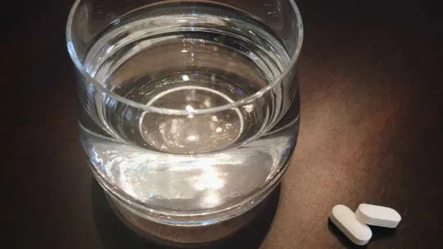 Un vaso de agua con un par te pastillas