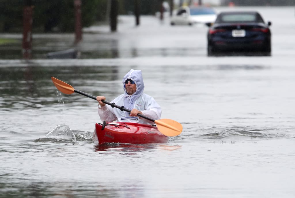 Hombre en cayac en mediode inundación