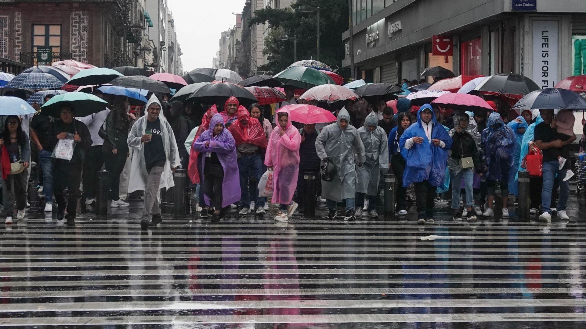 Decenas de personas buscan protegerse de la lluvia utilizando impermeables o paraguas. Foto: Cuartoscuro