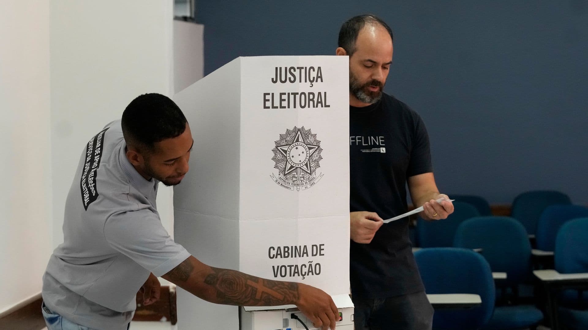 Coordinadores de mesa terminan de instalar una máquina de votación electrónica en un centro de votación.