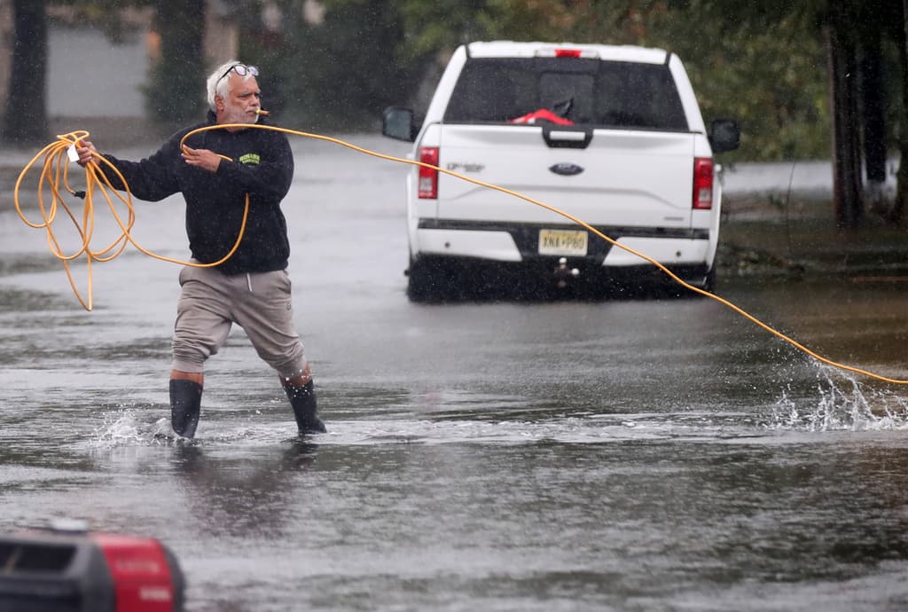 Hombre hace reparaciones, ante las inundaciones de la tormenta