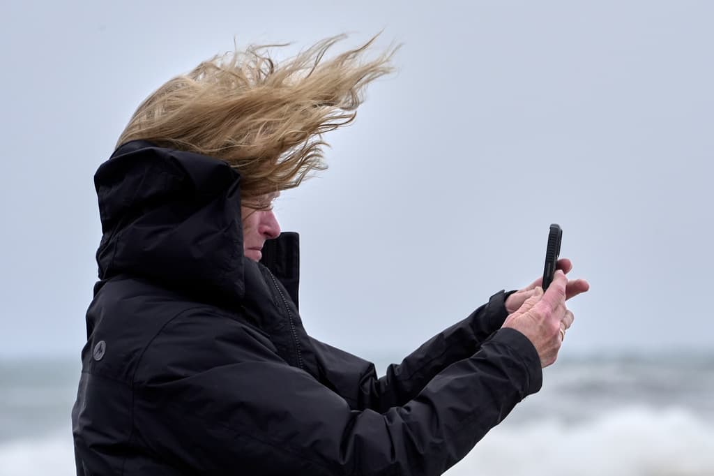 Una mujer se enfrenta a los fuertes vientos de la tormenta Noreaster