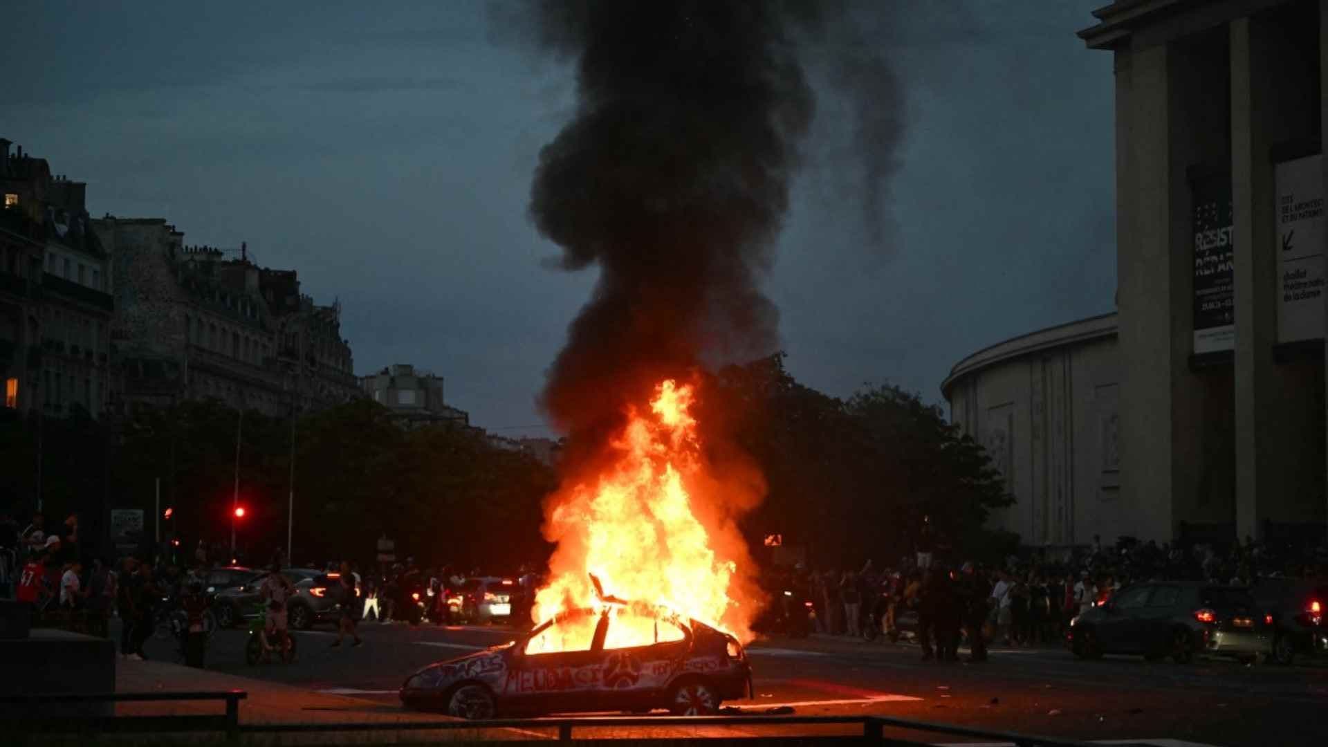 Un coche es incendiado mientras los hinchas del PSG celebran la victoria de su equipo en la final de la Liga de Campeones de la UEFA entre el Paris Saint-Germain (PSG) y el Arsenal FC, disputada en Budapest, en la Plaza del Trocadero de París el 30 de mayo de 2026. Foto: AFP