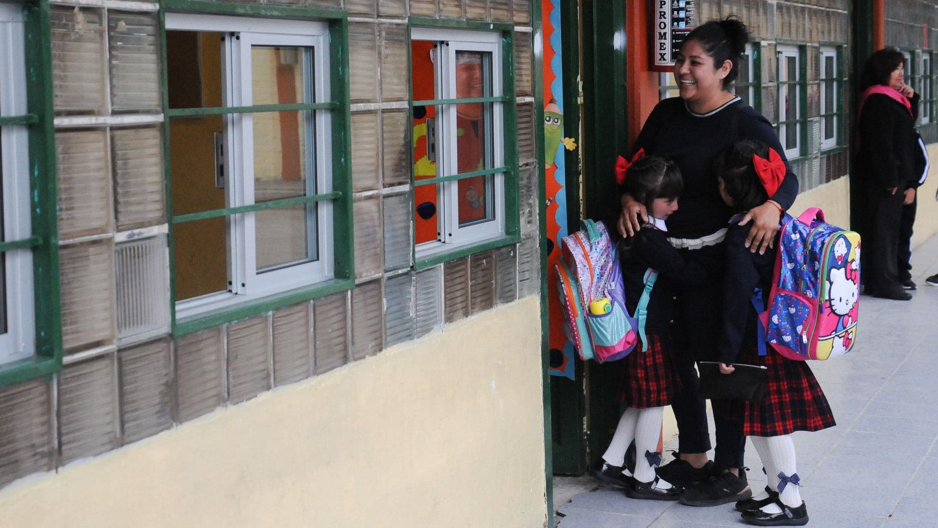 Una adre acompaña a sus dos hijas a entrar a su nuevo salón de clases. Foto: Cuartoscuro | Archivo