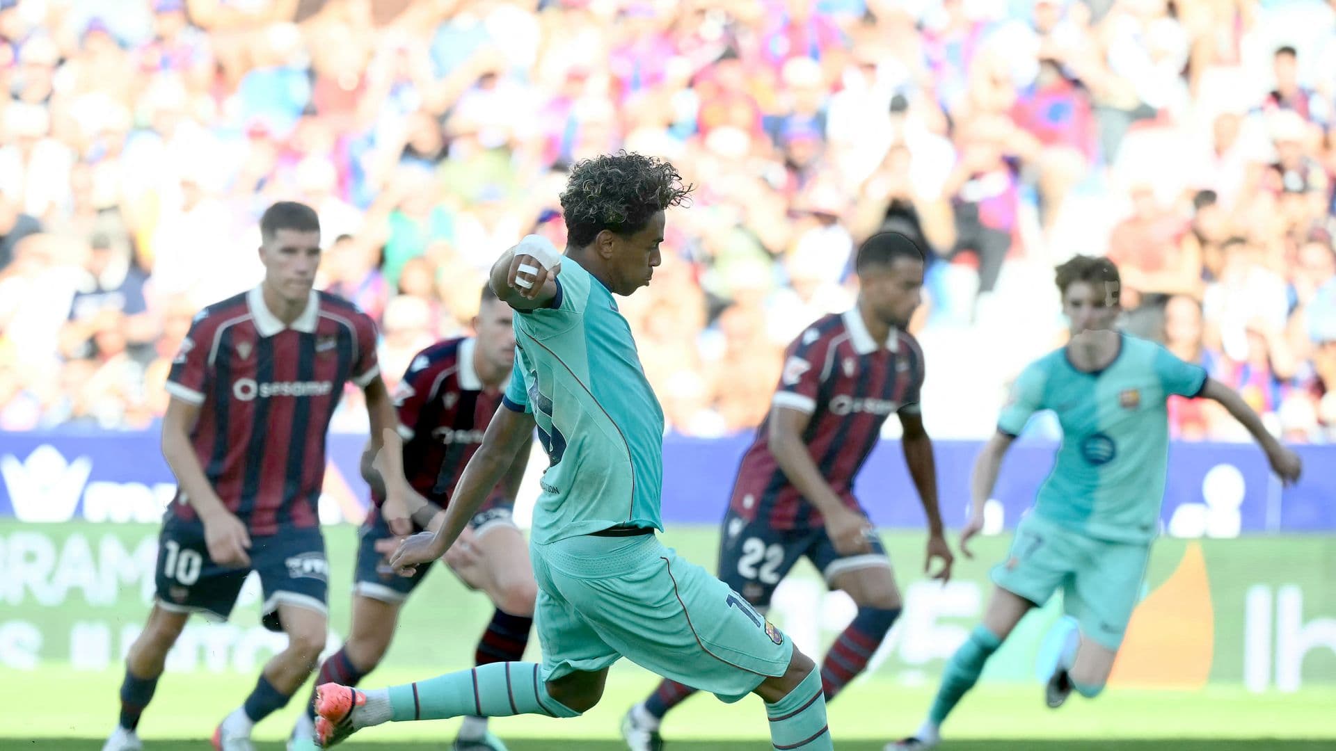 El delantero español del Barcelona, Lamine Yamal, número 10, anota el tercer gol de su equipo desde el punto de penalti durante el partido de la liga española entre el Levante UD y el FC Barcelona en el estadio Ciutat de Valencia, el 13 de septiembre de 2026. (Foto de JOSE JORDAN / AFP)